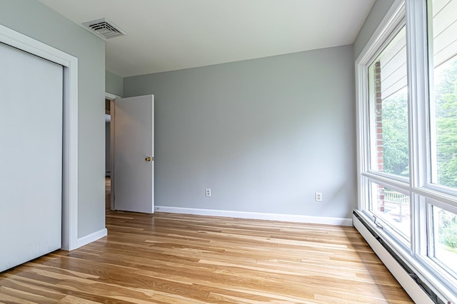 28 New Searles Rd, Nashua, NH 03062 - unfurnished bedroom with baseboard heating, light wood finished floors, and a closet