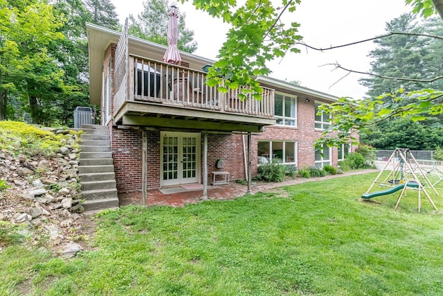 28 New Searles Rd, Nashua, NH 03062 - back of property with french doors, a yard, brick siding, stairs, and a playground