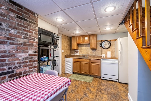 28 New Searles Rd, Nashua, NH 03062 - kitchen with white appliances, stacked washer / drying machine, decorative backsplash, recessed lighting, and brick wall