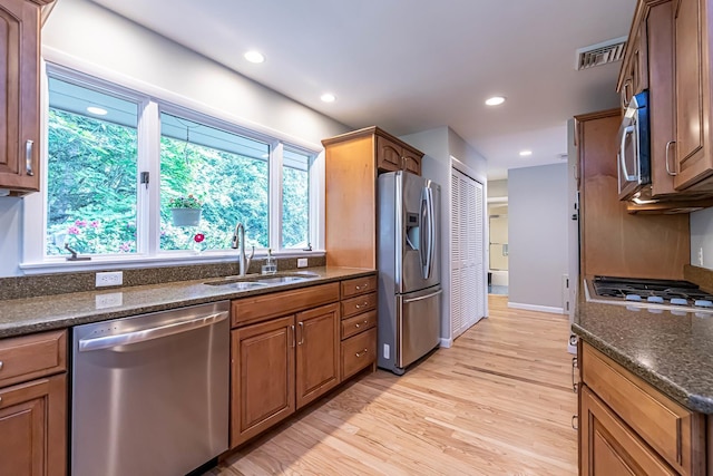 28 New Searles Rd, Nashua, NH 03062 - kitchen featuring appliances with stainless steel finishes, light wood-type flooring, recessed lighting, brown cabinetry, and dark stone countertops