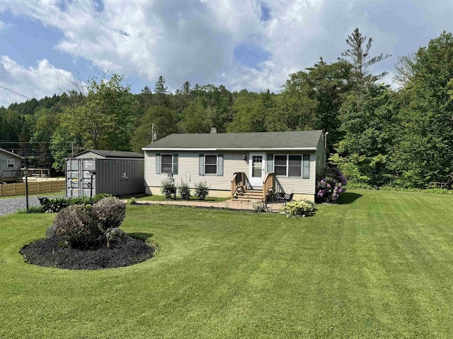 276 Minister Brook Rd, Worcester, VT 05682 - manufactured / mobile home with a front lawn, a storage shed, and a view of trees