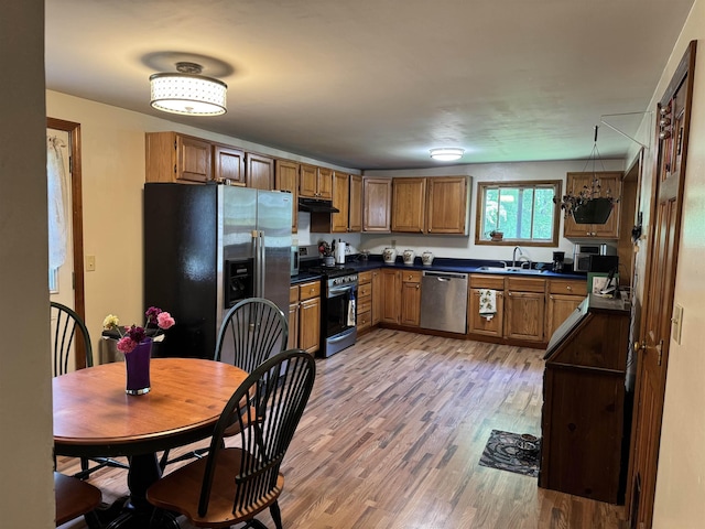 276 Minister Brook Rd, Worcester, VT 05682 - kitchen featuring appliances with stainless steel finishes, dark countertops, ventilation hood, brown cabinetry, and light wood-type flooring