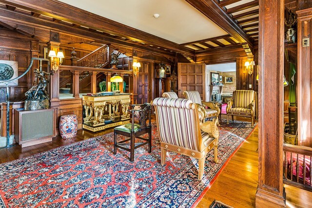 2 Croydon Brook Rd, Newport, NH 03773 - living area with wooden walls, beam ceiling, wood finished floors, ornamental molding, and stairs