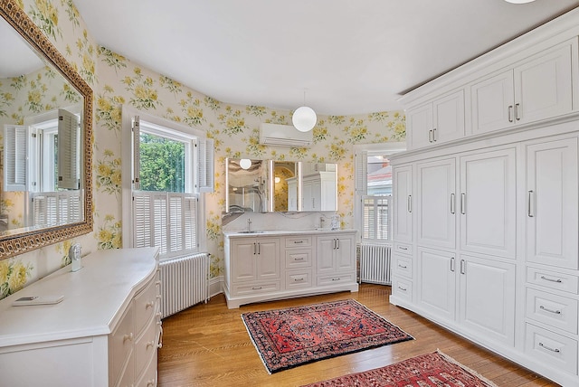 2 Croydon Brook Rd, Newport, NH 03773 - bathroom with wallpapered walls, radiator, an AC wall unit, wood finished floors, and vanity