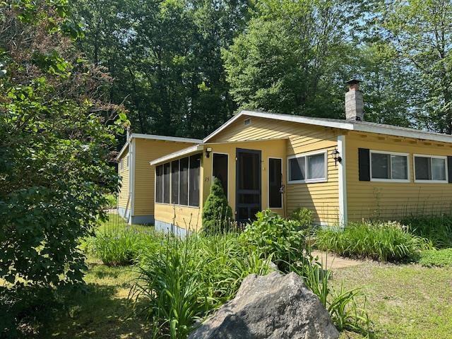 15 Milford St, Amherst, NH 03031 - view of home's exterior with a sunroom and a chimney