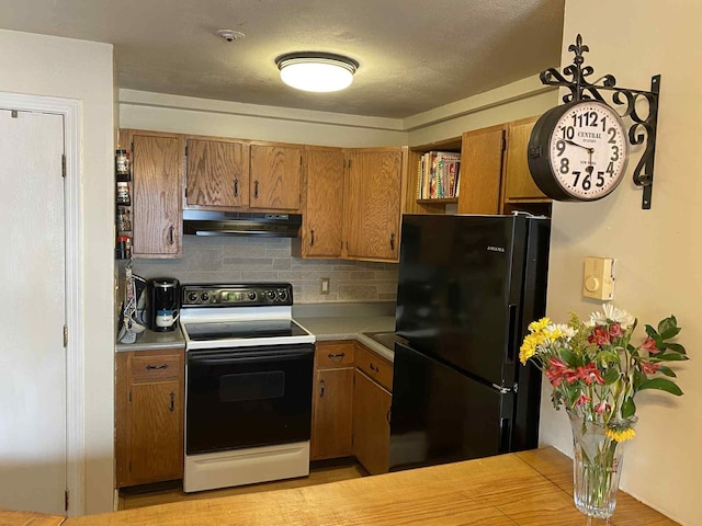 5 Swiftwater Dr Unit 8, Allenstown, NH 03275 - kitchen with freestanding refrigerator, range with electric stovetop, under cabinet range hood, light countertops, and decorative backsplash