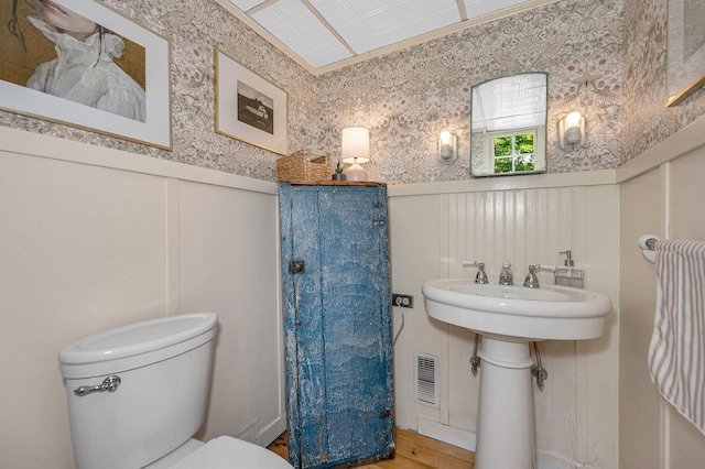 8 Main St, Brookline, NH 03033 - bathroom featuring a decorative wall, wainscoting, wallpapered walls, and wood finished floors