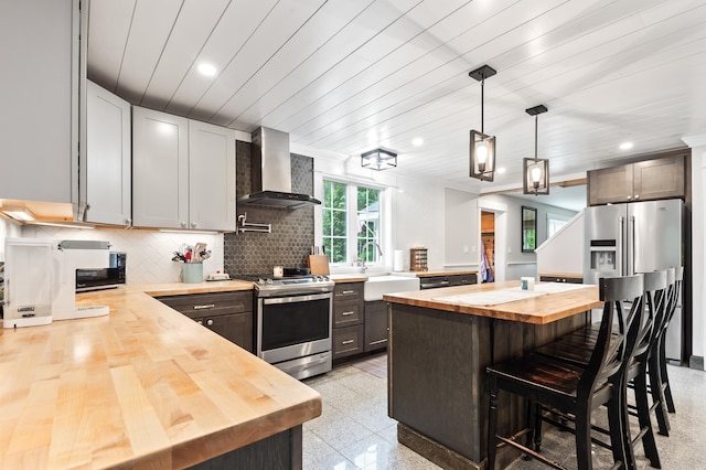 6 Rainbow Dr, Ossipee, NH 03864 - kitchen with wood counters, wall chimney range hood, appliances with stainless steel finishes, recessed lighting, and a kitchen island