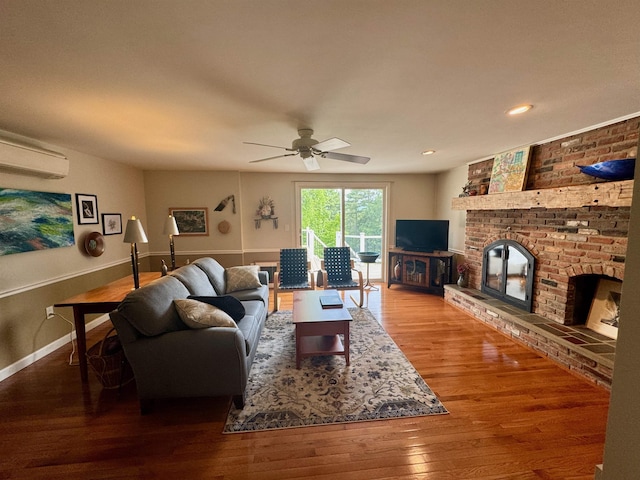 653 Skyboro E Rd, Pownal, VT 05261 - living room featuring an AC wall unit, a brick fireplace, wood finished floors, a ceiling fan, and recessed lighting