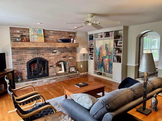 653 Skyboro E Rd, Pownal, VT 05261 - living area featuring ceiling fan, a fireplace, wood finished floors, and arched walkways
