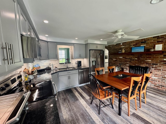 653 Skyboro E Rd, Pownal, VT 05261 - kitchen with stainless steel appliances, ceiling fan, dark wood-style flooring, dark countertops, and backsplash