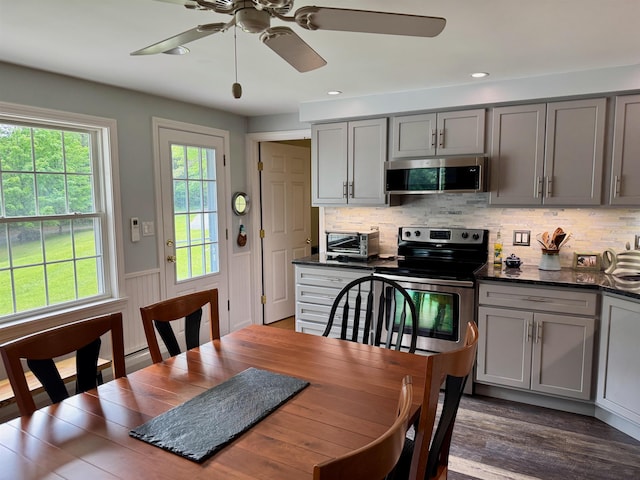 653 Skyboro E Rd, Pownal, VT 05261 - kitchen featuring gray cabinets, stainless steel appliances, ceiling fan, dark wood-type flooring, and a wainscoted wall