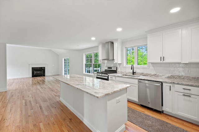 2 Gridley Rd, Warner, NH 03278 - kitchen featuring appliances with stainless steel finishes, wall chimney range hood, a fireplace, a kitchen island, and backsplash