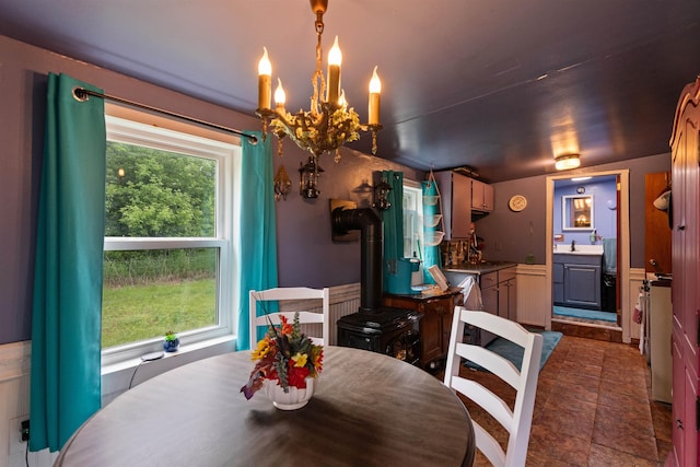 3123 Carter Hill Rd, Highgate, VT 05488 - dining room with a wood stove, a chandelier, and a wainscoted wall
