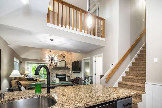 267 Village Cir Unit V-15, Killington, VT 05751 - kitchen featuring open floor plan, light stone countertops, a fireplace, and high vaulted ceiling