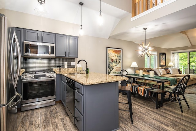 267 Village Cir Unit V-15, Killington, VT 05751 - kitchen featuring appliances with stainless steel finishes, a peninsula, gray cabinetry, dark wood-type flooring, and vaulted ceiling
