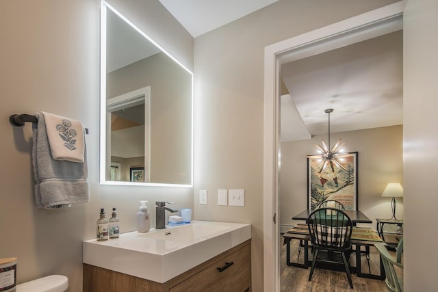267 Village Cir Unit V-15, Killington, VT 05751 - half bath with vanity, a chandelier, and wood finished floors