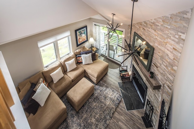 267 Village Cir Unit V-15, Killington, VT 05751 - living area featuring wood finished floors, a chandelier, a large fireplace, and vaulted ceiling