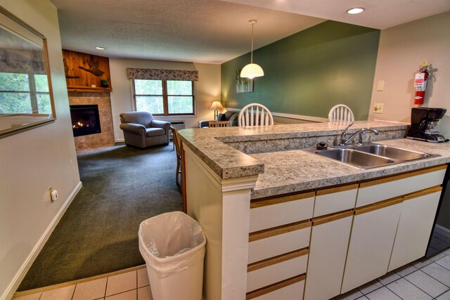 164 Deer Park Dr Unit 173A, Woodstock, NH 03262 - kitchen with white cabinets, a tiled fireplace, light countertops, decorative light fixtures, and recessed lighting