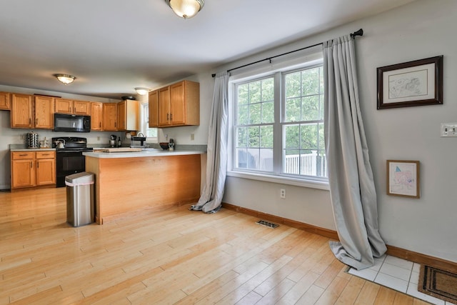 9 Mountain Rd, Goffstown, NH 03045 - kitchen featuring black appliances, light countertops, a peninsula, light wood finished floors, and brown cabinetry