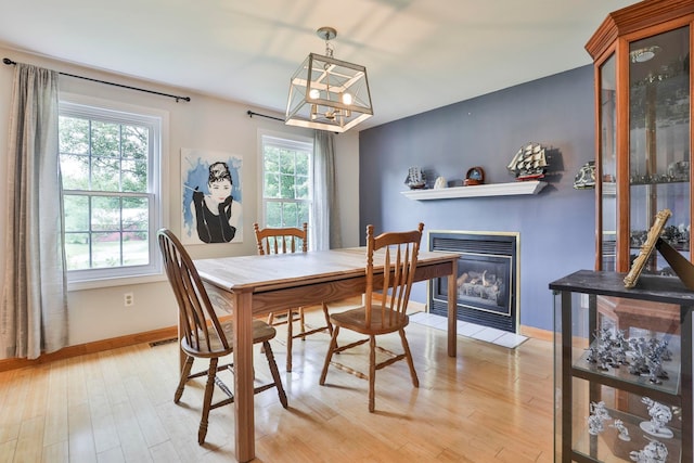 9 Mountain Rd, Goffstown, NH 03045 - dining area featuring light wood-style floors, a chandelier, and a glass covered fireplace
