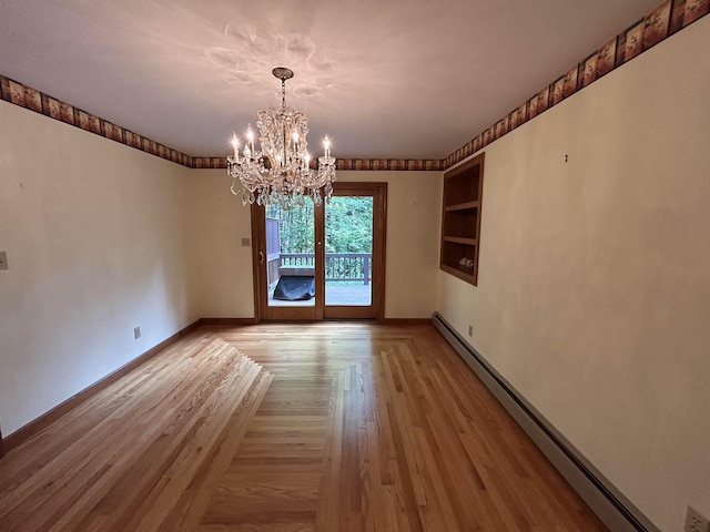 12 Juniper Ridge Rd, Exeter, NH 03833 - unfurnished room featuring a baseboard heating unit, a chandelier, built in features, and light wood finished floors