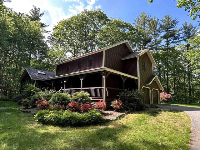 12 Juniper Ridge Rd, Exeter, NH 03833 - view of property exterior featuring a porch, a yard, asphalt driveway, and an attached garage