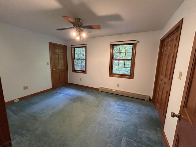 12 Juniper Ridge Rd, Exeter, NH 03833 - unfurnished bedroom featuring baseboard heating, multiple windows, dark colored carpet, and a ceiling fan