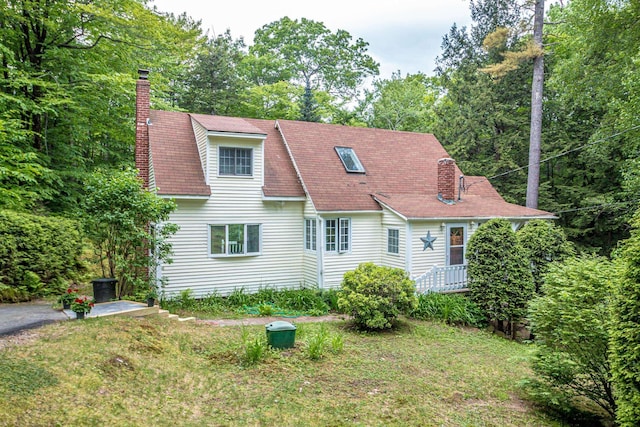 435 Rolling Ridge Rd, Bartlett, NH 03812 - rear view of house featuring a chimney, a yard, and roof with shingles