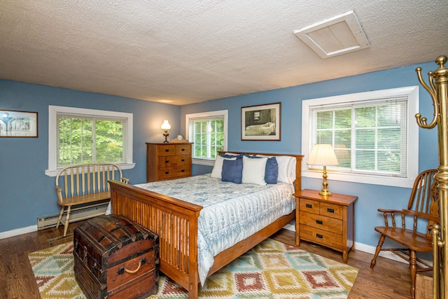 435 Rolling Ridge Rd, Bartlett, NH 03812 - bedroom with a baseboard heating unit, a textured ceiling, wood finished floors, and attic access