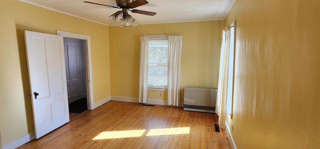 7-9 Elm St, Waterbury, VT 05676 - spare room with crown molding, light wood-type flooring, ceiling fan, and heating unit