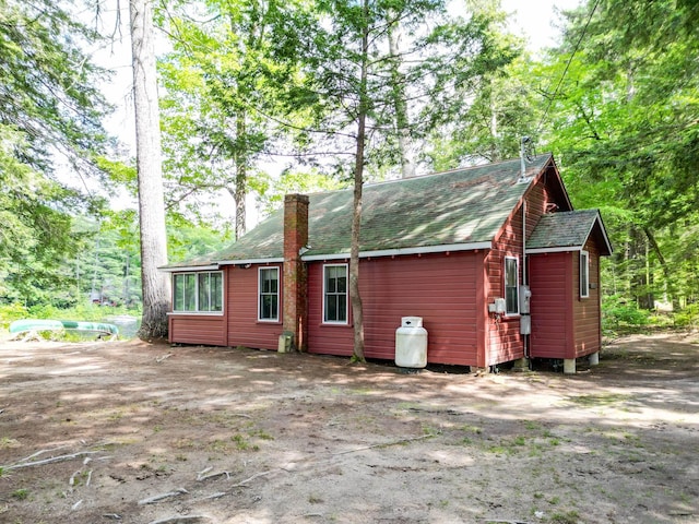 28 Brook Ln, Conway, NH 03818 - back of house featuring a shingled roof and a chimney
