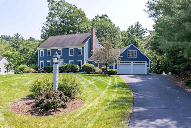 48 Cider Mill Rd, Bedford, NH 03110 - colonial-style house featuring asphalt driveway, a front yard, a chimney, and an attached garage