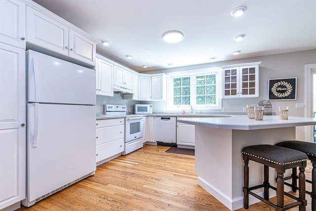 48 Cider Mill Rd, Bedford, NH 03110 - kitchen featuring white appliances, a breakfast bar, light wood-type flooring, white cabinets, and recessed lighting