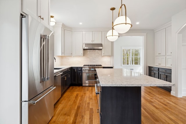 131 Exeter Rd, North Hampton, NH 03862 - kitchen with high quality appliances, under cabinet range hood, a kitchen island, white cabinetry, and light stone counters