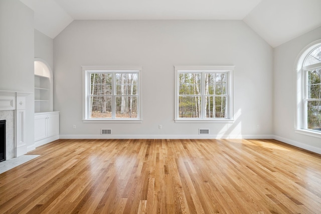 131 Exeter Rd, North Hampton, NH 03862 - unfurnished living room featuring light wood-type flooring, a fireplace, built in shelves, and high vaulted ceiling