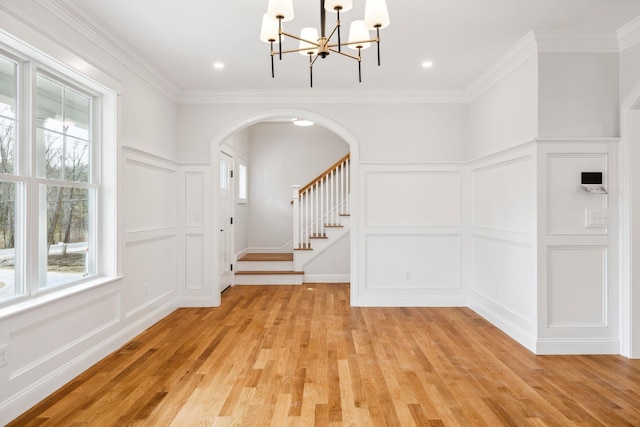 131 Exeter Rd, North Hampton, NH 03862 - entryway with a decorative wall, healthy amount of natural light, a chandelier, arched walkways, and light wood-style flooring