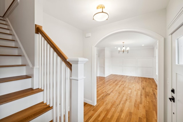 131 Exeter Rd, North Hampton, NH 03862 - entrance foyer featuring arched walkways, light wood-type flooring, stairway, and a chandelier