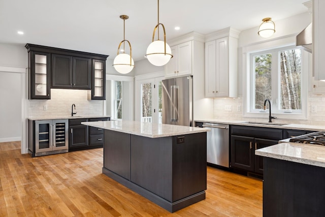 131 Exeter Rd, North Hampton, NH 03862 - kitchen with stainless steel appliances, wine cooler, glass insert cabinets, backsplash, and recessed lighting