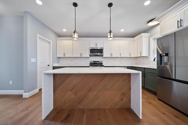 13 Raven St, Nashua, NH 03060 - kitchen featuring appliances with stainless steel finishes, tasteful backsplash, wood finished floors, white cabinetry, and recessed lighting