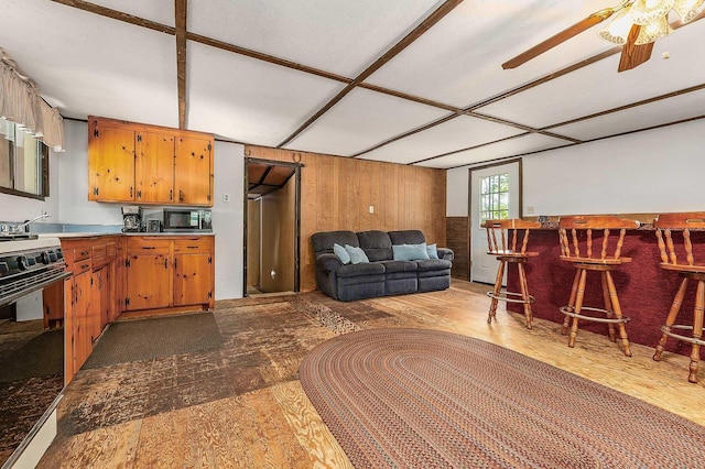 11 Dearborn Rd, Wakefield, NH 03830 - kitchen with black microwave, white range oven, a ceiling fan, wood finished floors, and wooden walls