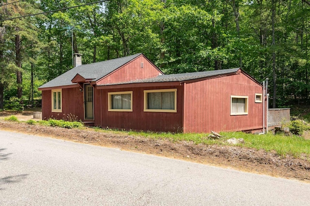 11 Dearborn Rd, Wakefield, NH 03830 - view of front of house with a chimney, roof with shingles, and view of wooded area