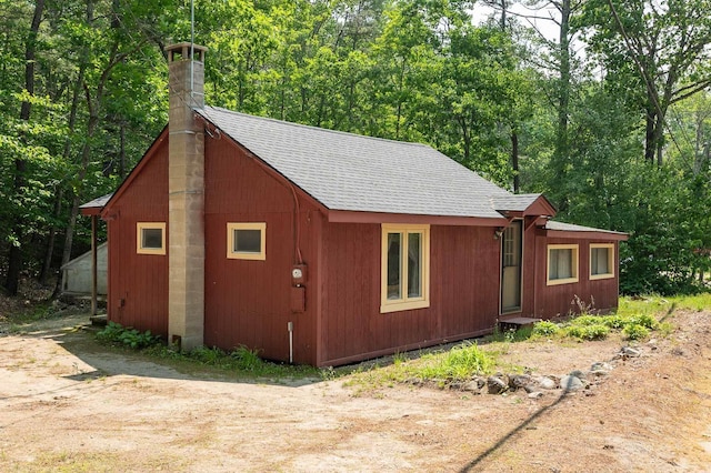 11 Dearborn Rd, Wakefield, NH 03830 - view of home's exterior featuring roof with shingles and a chimney