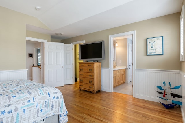 5 Fellows Ave, Hampton, NH 03842 - bedroom with wainscoting, light wood-style flooring, lofted ceiling, and ensuite bath