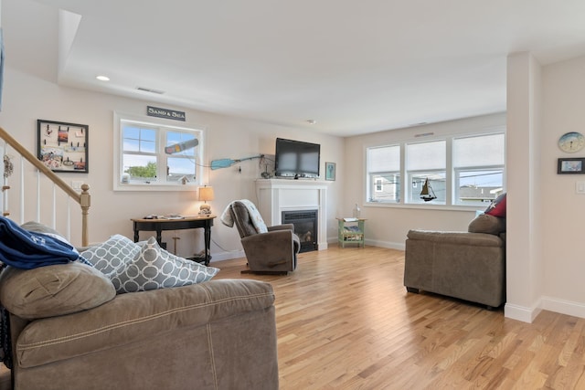 5 Fellows Ave, Hampton, NH 03842 - living area with light wood-type flooring, a glass covered fireplace, stairway, and recessed lighting