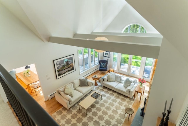 137 Wildes District Rd, Kennebunkport, ME 04046 - living room with high vaulted ceiling, a baseboard heating unit, a wood stove, and light wood finished floors