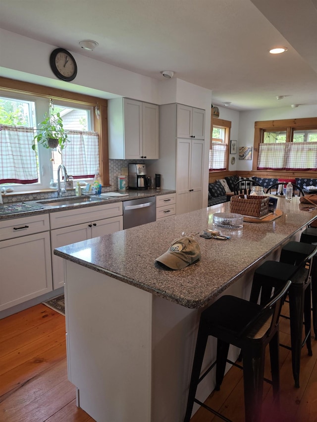 104 Middle St, Lancaster, NH 03584 - kitchen featuring stainless steel dishwasher, stone counters, a breakfast bar area, light wood-style floors, and recessed lighting