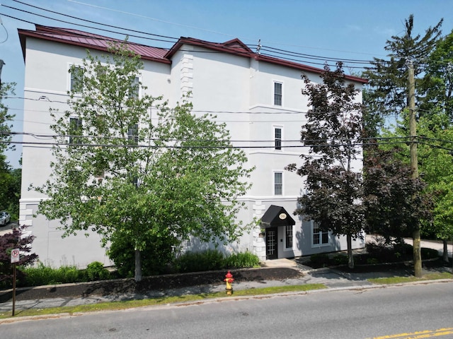96 River Rd Unit 205, Manchester, NH 03104 - view of front facade featuring stucco siding, a metal roof, and a standing seam roof