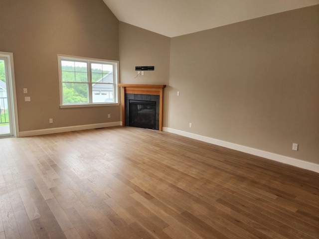 22 John Hardie Way, Chichester, NH 03234 - unfurnished living room featuring light wood finished floors, high vaulted ceiling, and a tile fireplace