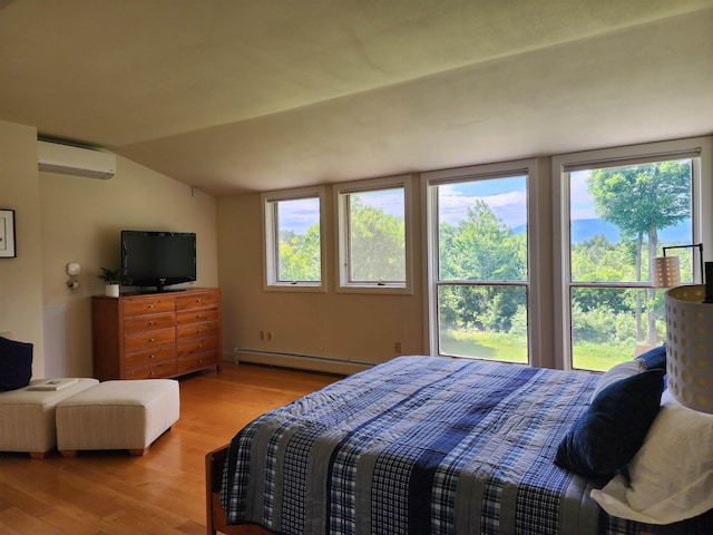 201 Lower Judson Ln, Stowe, VT 05672 - bedroom with baseboard heating, light wood-type flooring, a wall mounted AC, multiple windows, and vaulted ceiling